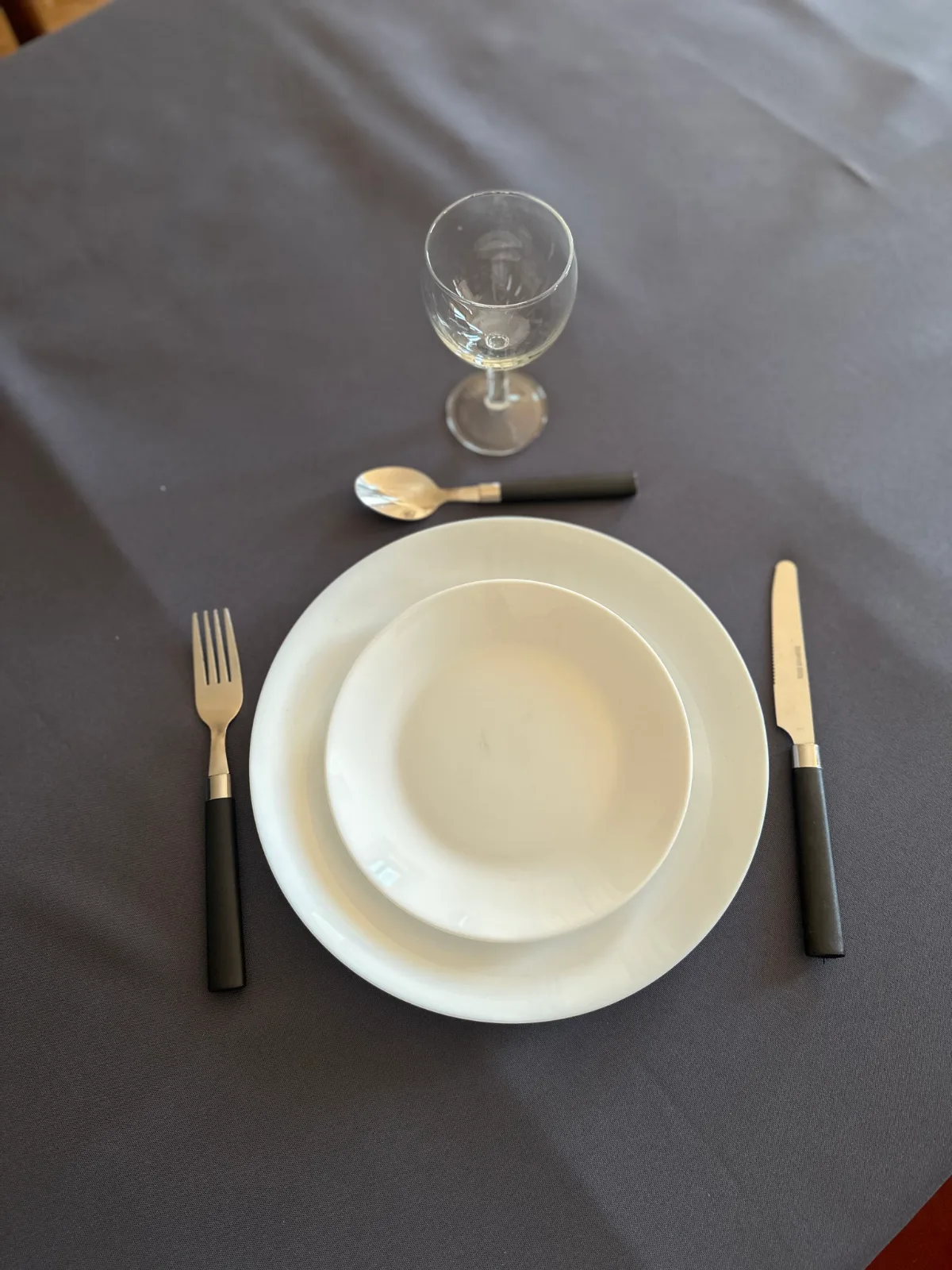 Assiettes et couverts vus de dessus, prêts pour une réception